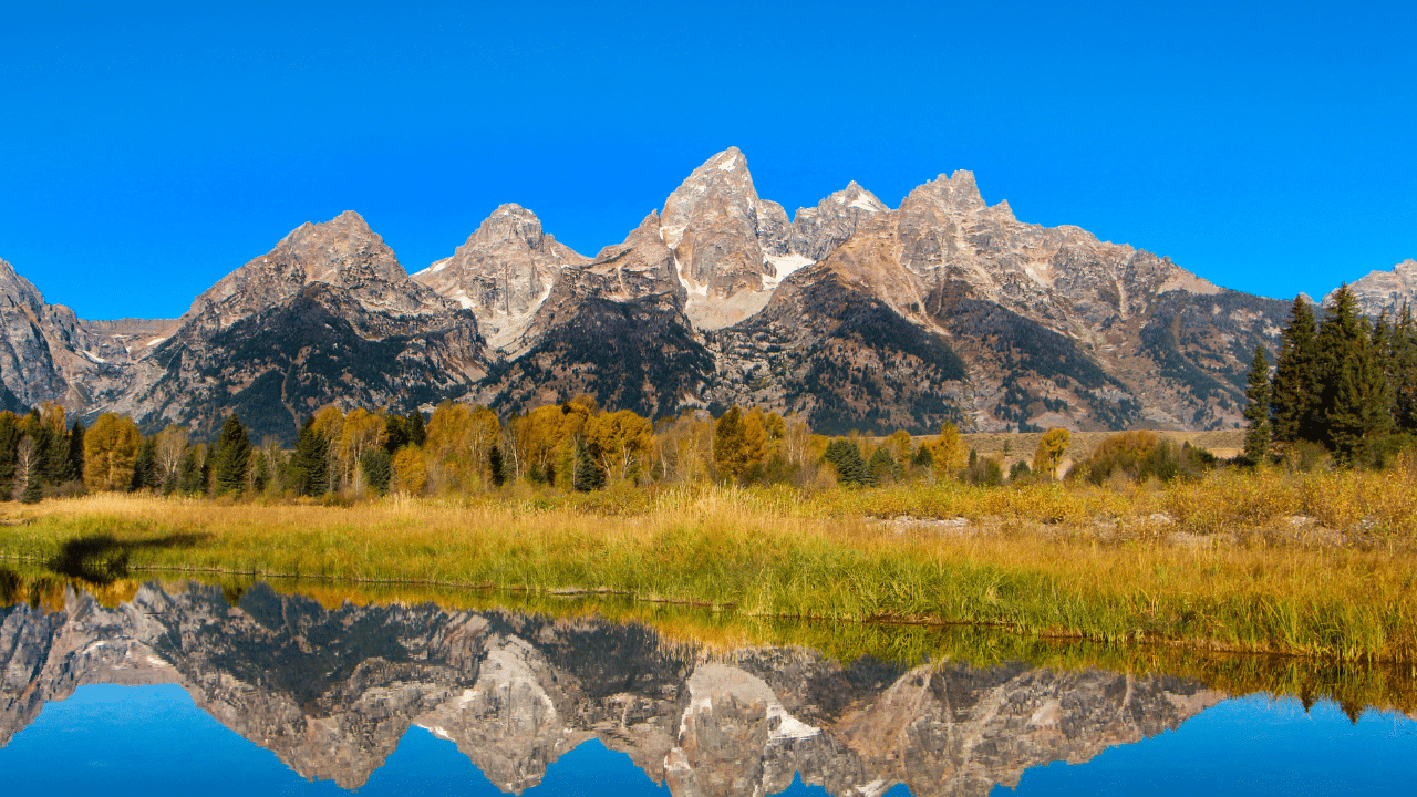 The Grand Teton Mountains are reflected in the water during a Half Marathon.