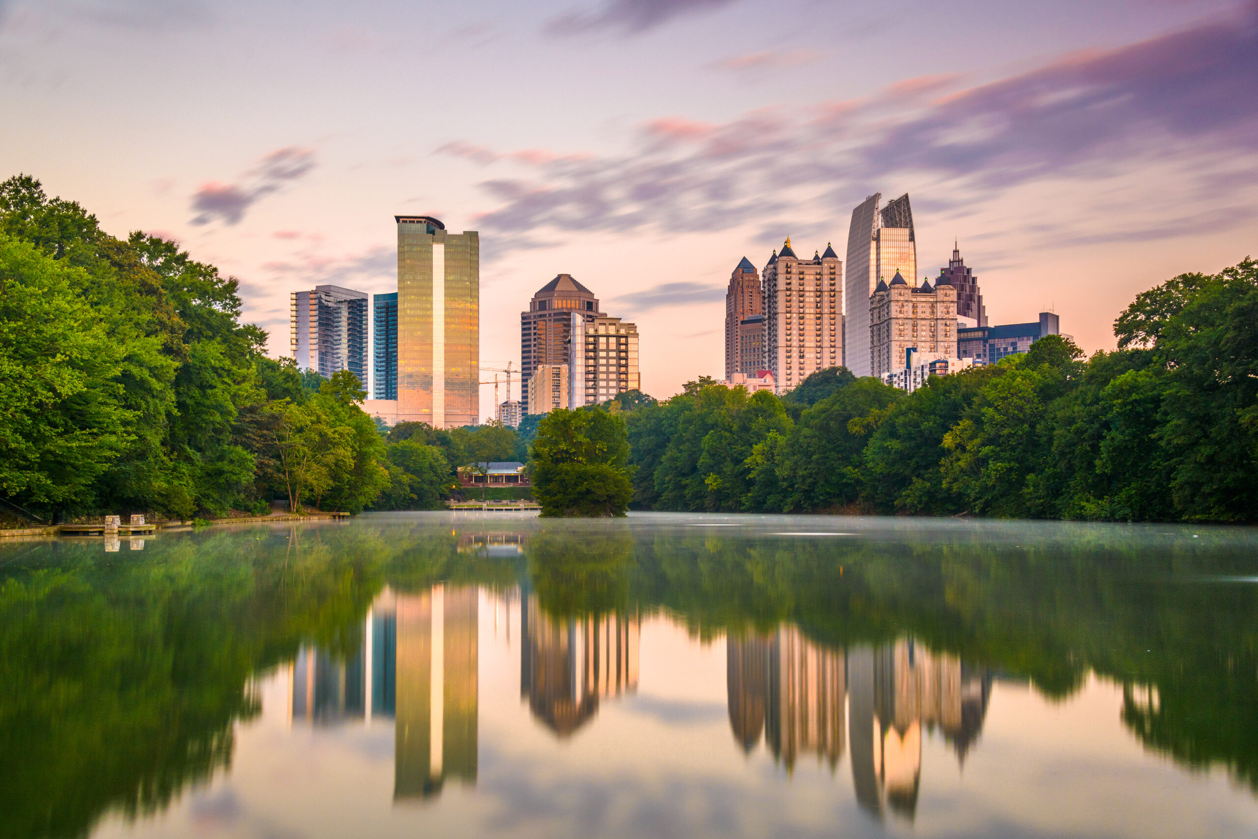The Peachtree Road Race city skyline is reflected in a body of water.