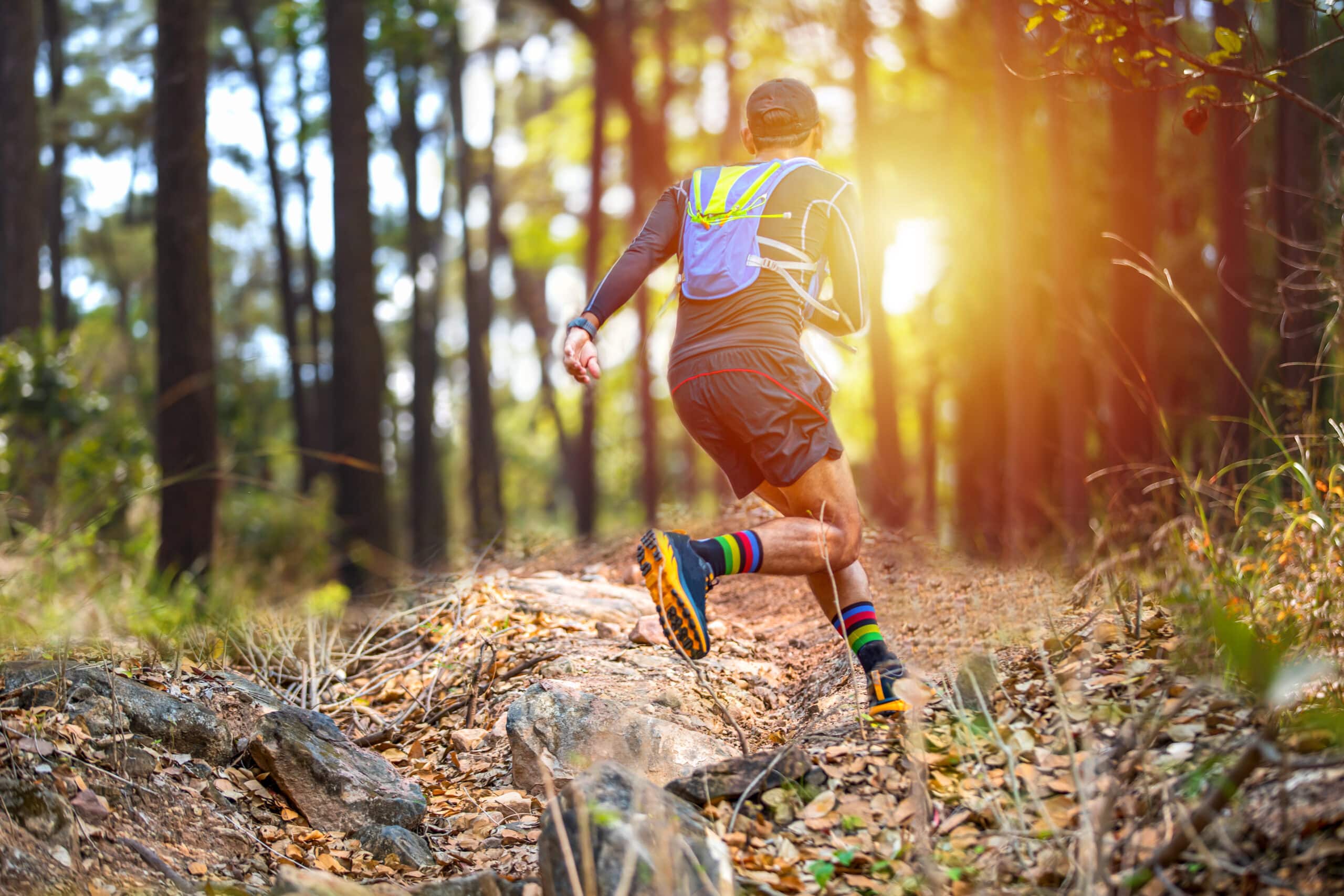 A man is running through the woods wearing a pair of running shoes.